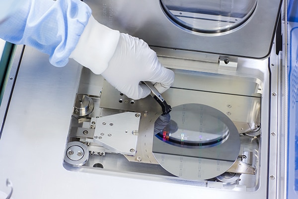A delicate wafer is placed into an atomic layer deposition machine Image of a delicate wafer is placed into an atomic layer deposition machine