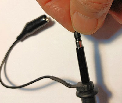 The replacement pin being screwed into the probe by turning it in the clockwise direction