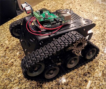 Image of Devastator chassis, controller board, a motor control expansion board, and an ultrasonic sensor