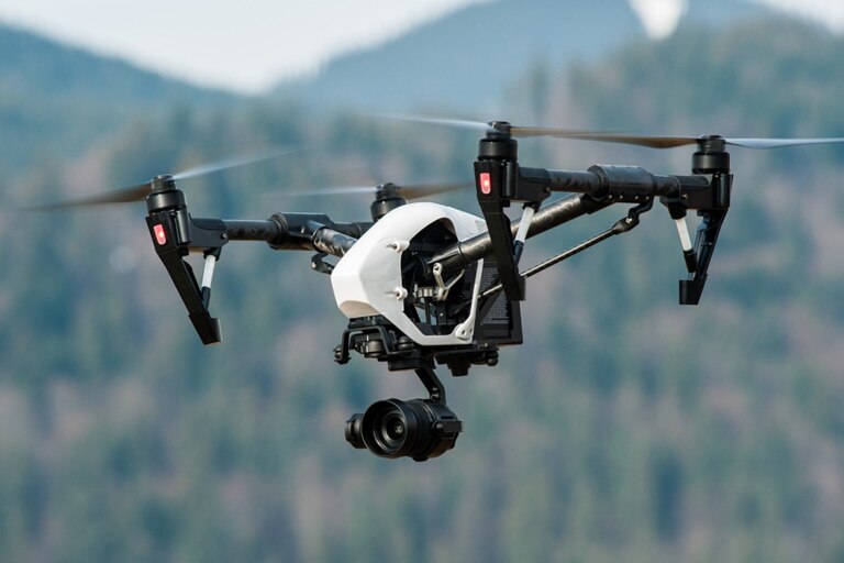 Quadcopter drone with camera operating near some mountains